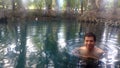 Latino adult man swims in crystal clear spring water of the Media Luna natural lagoon in the municipality Royalty Free Stock Photo