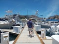 Latino adult man walking on the marina dock to get on his yacht and take a tourist ride