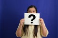 Latino adult woman shows a question mark, wonders, doubts, suspects, assumes, fears and distrusts