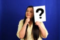 Latino adult woman shows a question mark, wonders, doubts, suspects, assumes, fears and distrusts