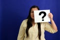 Latino adult woman shows a question mark, wonders, doubts, suspects, assumes, fears and distrusts