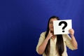 Latino adult woman shows a question mark, wonders, doubts, suspects, assumes, fears and distrusts