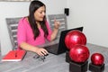 Latino adult woman working at home office in her dining room with laptop, glasses and notebook in the new normal due to the Covid-