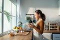 Latino attractive woman wear apron cook green salad in kitchen at home. Young beautiful girl feeling happy and enjoy eating Royalty Free Stock Photo