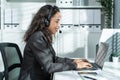 Latino beautiful business woman call center smile while work in office. Attractive young female employee worker in formal wear sit