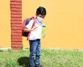 Latino boy with uniform shirt, mask, backpack, notebook and bottle of water back to school in the new normal due to the Coronaviru Royalty Free Stock Photo