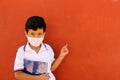 Latino boy with uniform shirt, mask, backpack, notebook and bottle of water back to school in the new normal due to the Coronaviru Royalty Free Stock Photo