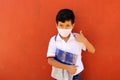 Latino boy with uniform shirt, mask, backpack, notebook and bottle of water back to school in the new normal due to the Coronaviru Royalty Free Stock Photo