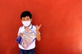 Latino boy with uniform shirt, mask, backpack, notebook and bottle of water back to school in the new normal due to the Coronaviru Royalty Free Stock Photo