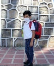 Latino boy with uniform shirt, mask, backpack, notebook and bottle of water back to school in the new normal due to the Coronaviru Royalty Free Stock Photo