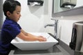 Latino boy 6 years old washing hands to avoid contagion of bacteria and covid-19