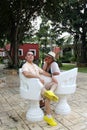 Couple sitting on a bench confidant chairs in Merida in Yucatan Mexico show their love with flirtatious looks and kisses