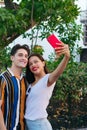 Latino couple taking selfie in the park