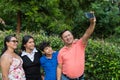 Latino family with two teenagers use a cell phone to take a selfie Royalty Free Stock Photo