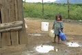 Latino girl goes to fetch water in mountain landscape Royalty Free Stock Photo