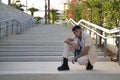 Latino and Hispanic boy, young and nonconformist, rebellious, with beige jacket and pants, crouching, posing looking at the camera Royalty Free Stock Photo