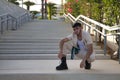 Latino and Hispanic boy, young and nonconformist, rebellious, with beige jacket and pants, crouching, posing looking at the camera Royalty Free Stock Photo