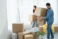 Latino man with beard and Asian woman couple help to carry packed cardboard boxes into their new home where they were moving in Royalty Free Stock Photo