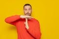 Latino man with a beard in a red sweatshirt making the time-out gesture, he needs a break from the pace of life demanded