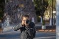 Latino photojournalist taking a picture with his camera