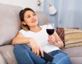 Latino woman with glass of red wine watching tv Royalty Free Stock Photo
