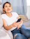 Latino woman with glass of red wine watching tv Royalty Free Stock Photo