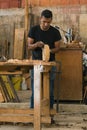 Latino worker doing his daily chores. craft procedures with wood.