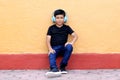 Brown Latino 9 year old boy with anti noise headphones for children with asperger syndrome, autism spectrum disorder, ADHD