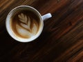 Latte art coffee on the dark wooden table