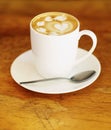 Latte art, coffee and drink on table in cafe, closeup of hot beverage and artistic heart design with milk foam