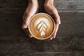 Latte art coffee with heart tree  shape in coffee cup holding by hand Royalty Free Stock Photo