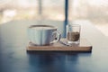 Latte art coffee on the white cup of hot coffee on wooden tray and dark table. Royalty Free Stock Photo