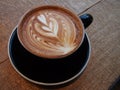 Latte art coffee on the wooden desk. Royalty Free Stock Photo