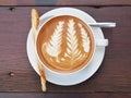 Latte art coffee on the wooden desk. Royalty Free Stock Photo