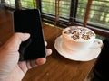 Latte Art Coffee and Young Businessman Hold a Phone with Blank Space Screen For advertising, enter a message or promotion topic at Royalty Free Stock Photo