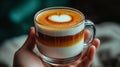 Latte art held in hand, cozy cafe scene Royalty Free Stock Photo
