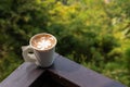 Latte art paper cup with blur trees Royalty Free Stock Photo