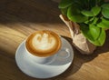 Latte or Cappuccino art coffee cup top view on wood table with sunlight in cafe Royalty Free Stock Photo