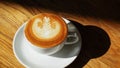 Latte or Cappuccino art coffee cup top view on wood table with sunlight in cafe Royalty Free Stock Photo