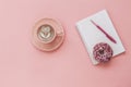 Latte Coffee cup, delicious pink donut with sprinkle, notebook for notes and pen on pink paper background Royalty Free Stock Photo