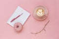 Latte Coffee cup, delicious pink donut with sprinkle, notebook for notes and pen on pink paper background Royalty Free Stock Photo