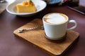 Latte coffee cup with spoon on wooden plate Royalty Free Stock Photo