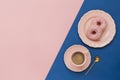 Latte Coffee cup and two delicious pink donut with sprinkle  on pink  and blue paper background Royalty Free Stock Photo