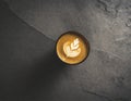 Latte coffee with milk pattern, latte art. Dark gray stone background, dark mug