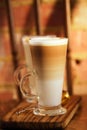 latte coffee in tall glasses on vintage chair with old brick wall Royalty Free Stock Photo