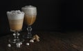 Latte coffee with tasty foam in glass with marshmallow on dark rustic table over black background Royalty Free Stock Photo