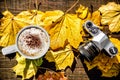 Latte and Film Camera Sitting on Leaf Covered Table