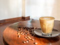 Latte hot coffee art design to white heart shape on top in clear glass with a coaster black color. Placed on a brown wooden table Royalty Free Stock Photo