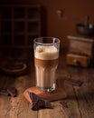 Latte macchiato coffee glass with chocolate on wooden table Royalty Free Stock Photo