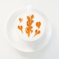 Latte with orange leaf latte art in a white cup on a saucer Royalty Free Stock Photo